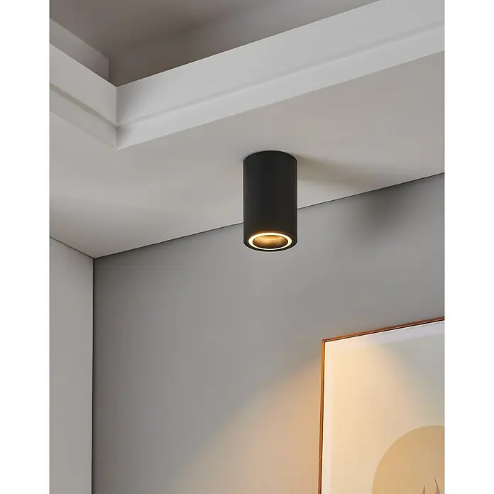 Eglo connect.z LED-Spot Carosso-Z - Ø x H: 80 x 95 mm, 4,9 W - Nahaufnahme einer modernen schwarzen Deckenleuchte, die ein warmes Licht in einem stilvollen Raum ausstrahlt.
