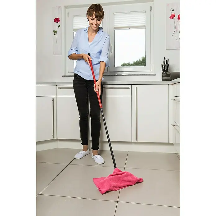 Vileda Microfibre Bodentuch Colors Duo Pack - 2 Stk. - Frau wischt mit einem Mopp und einem rosafarbenen Tuch den Boden in der Küche. Der Mopp erleichtert die Reinigung und sorgt für Sauberkeit.