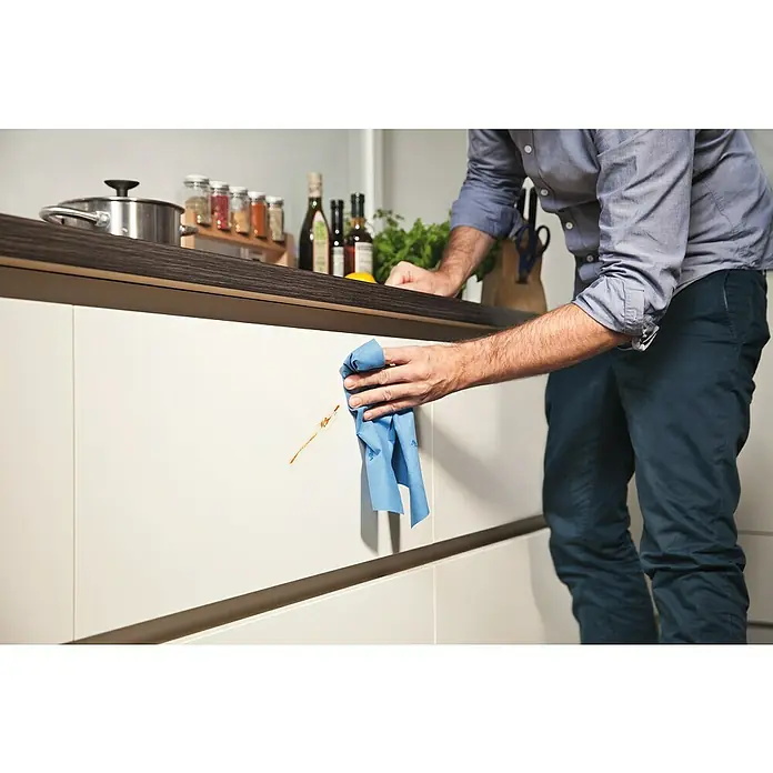Vileda Microfibre Allzwecktuch MULTI - Mikrofaser, 4 Stk. - Mann wischt mit einem blauen Vileda-Tuch eine Küchentür ab. Das Tuch ist ideal für die Reinigung von Oberflächen und entfernt Flecken mühelos.
