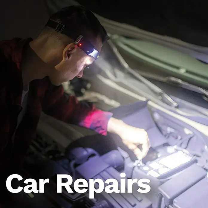 Stirnlampe Handy Brite Work Light - 260 lm - Ein Mann repariert ein Auto mit einer Stirnlampe, die für optimale Sicht sorgt. Perfekt für nächtliche Reparaturen.