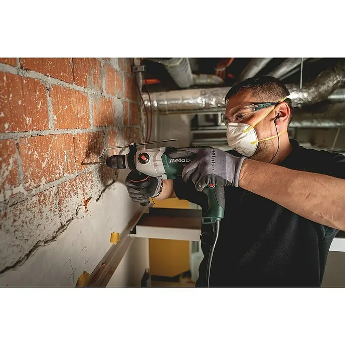 Metabo Schlagbohrmaschine - 800 W, Schnellspannbohrfutter, Max. Schlagzahl: 51.200 /min - Mann bohrt mit einer Metabo Schlagbohrmaschine ein Loch in eine Ziegelwand, Schutzmaßnahmen sind getroffen.