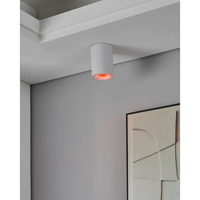 Eglo connect.z LED-Spot Carosso-Z - 4,9 W - Nahaufnahme einer weißen Deckenleuchte mit rotem Licht vor einer grauen Wand und einem Kunstwerk.