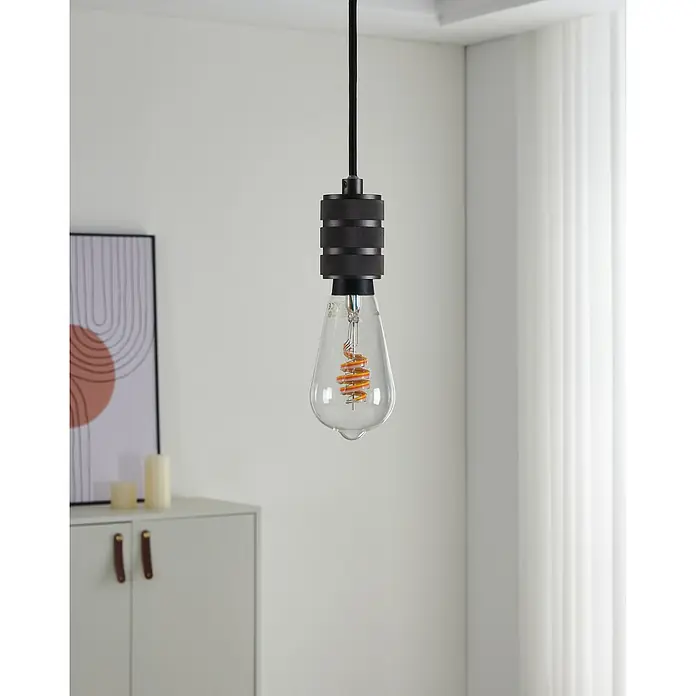 Eglo connect.z Smart-LED-Lampe - E27, Dimmbar, RGBW, 5 W, 400 lm, ST64, 1 Stk. - Nahaufnahme einer hängenden Glühbirne mit schwarzer Fassung und dekorativem Filament in einem modernen Raum.