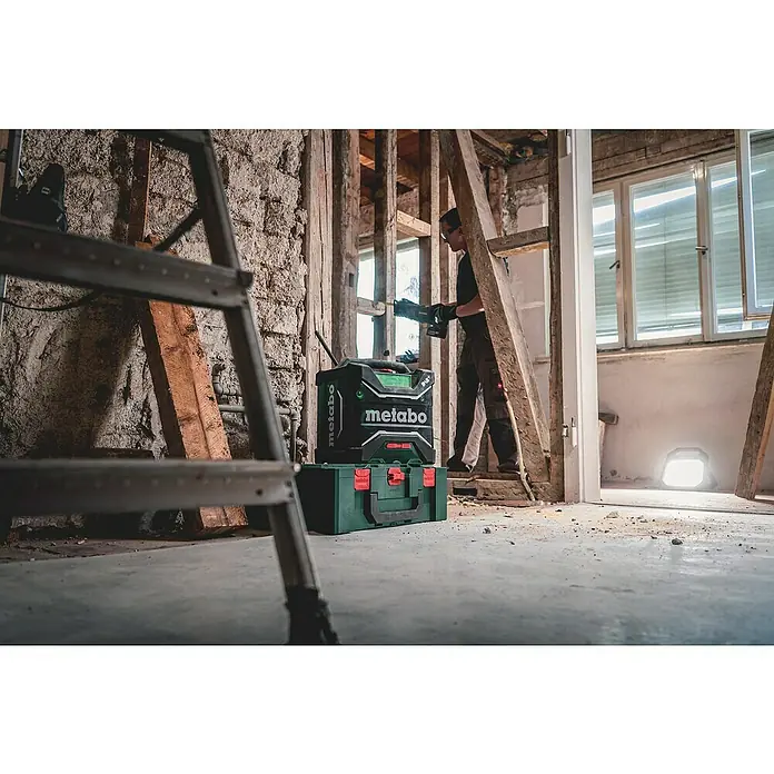 Metabo CAS 18V Akku-Baustellenradio RC 12-18 32 W BT DAB+ - 18 V, Ohne Akku, 87,5 - 108,0 kHz (FM) - Baustelle mit Metabo-Baustellenradio und Werkzeugkasten. Der Arbeiter verwendet eine Metabo-Säge für Bauarbeiten im Innenraum.