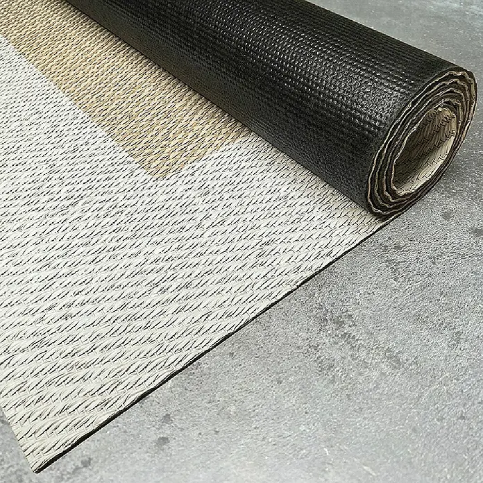Alfombra de vinilo Living - Beige/Blanco, 180 x 120 cm - Un rollo de material para techos negro yace parcialmente sobre una superficie gris con un patrón sutil.