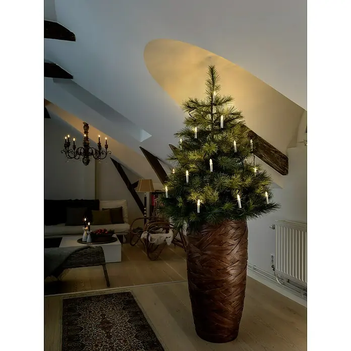 Konstsmide Baumkerzen-Set - Grün, LED - Stimmungsvolle Aufnahme eines stilvollen Weihnachtsbaums im Wohnzimmer, geschmückt mit traditionellen Kerzen und warmen Lichtern.