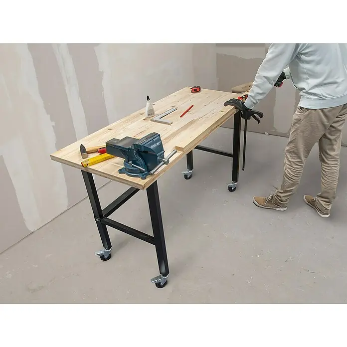 Rikta Werkbank mit Rollen - L x B: 140 x 60 cm, Arbeitshöhe: 84 cm, Belastbarkeit: 200 kg - Aufnahme eines mobilen Werktisches mit einer blauen Schraubstock und verschiedenen Werkzeugen, der Funktionalität und Komfort vereint.