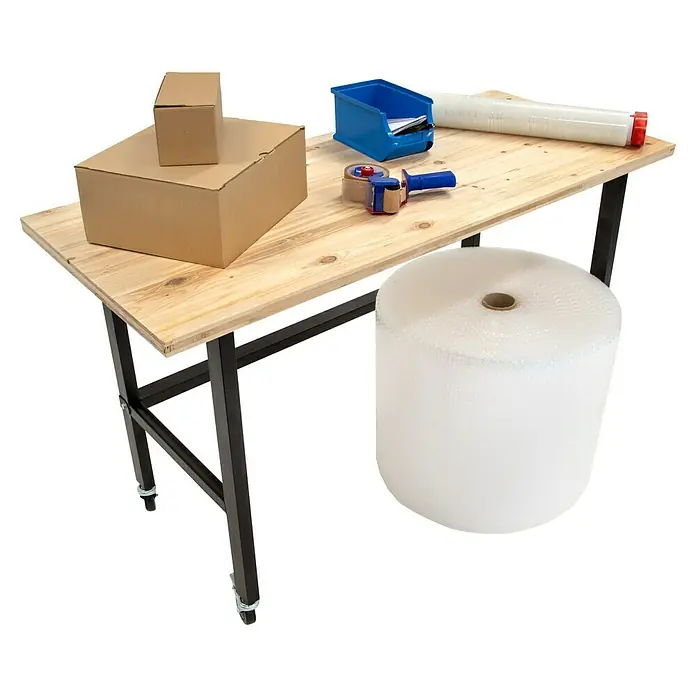 Rikta Werkbank mit Rollen - L x B: 140 x 60 cm, Arbeitshöhe: 84 cm, Belastbarkeit: 200 kg - Produktfoto eines Packtisches mit Kartons, Klebebandabroller, Luftpolsterfolie und einem blauen Behälter. Ideal für Versand und Verpackung.