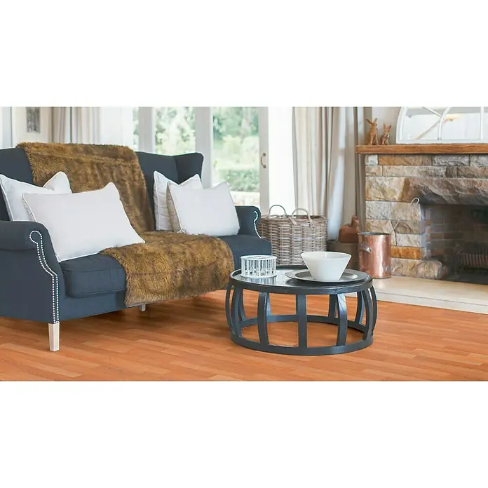 Tarkett Suelo de PVC a metros Class - Efecto madera, Ancho: 2 m - Primer plano de una elegante sala de estar con un sofá azul, una mesa de centro y una chimenea, creando un ambiente acogedor.