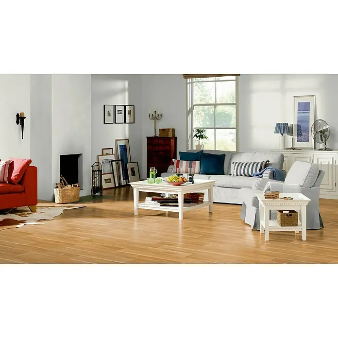 Tarkett Suelo de PVC a metros Matrix hazelnut - Efecto madera, Ancho: 3 m - La imagen muestra una sala de estar luminosa con una mesa de centro blanca, un sofá y un sillón, creando un ambiente acogedor.