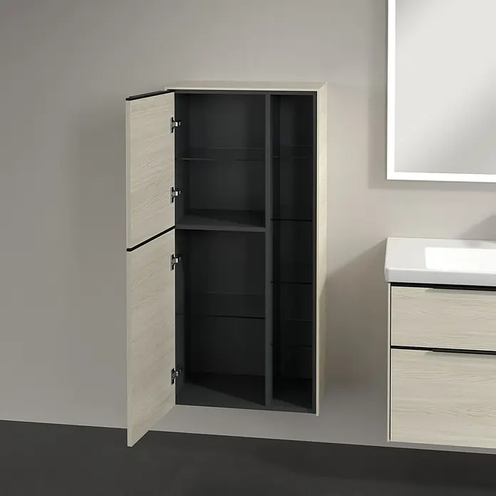 Villeroy & Boch Subway 3.0 Seitenschrank - B x T x H: 57,4 x 36,2 x 120 cm, White Oak, DIN Anschlag: Links, Farbe Griff: Volcano Black - Das Bild zeigt einen offenen Badezimmerschrank mit Regalen, der neben einem Waschbecken und einem Spiegel an einer Wand montiert ist.