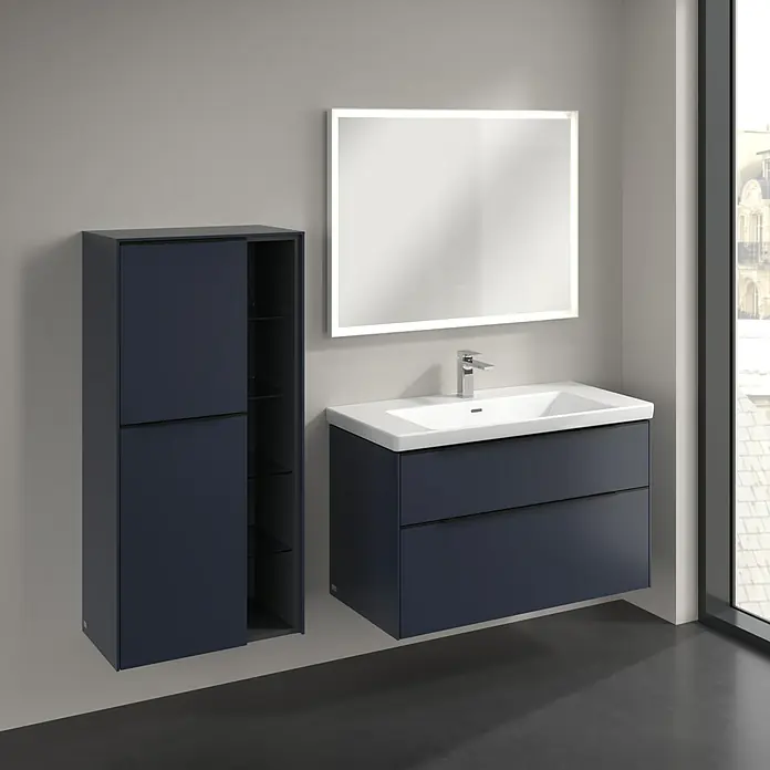 Villeroy & Boch Subway 3.0 Seitenschrank - B x T x H: 57,4 x 36,2 x 120 cm, Marine Blue, DIN Anschlag: Links, Farbe Griff: Volcano Black - Badezimmer mit Waschbeckenunterschrank in Dunkelblau, Spiegelschrank mit Beleuchtung und Hochschrank mit Regalen.