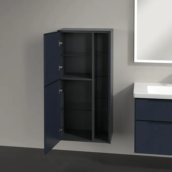 Villeroy & Boch Subway 3.0 Seitenschrank - B x T x H: 57,4 x 36,2 x 120 cm, Marine Blue, DIN Anschlag: Links, Farbe Griff: Volcano Black - Ein offener, dunkelblauer Badezimmerschrank mit Glasböden neben einem beleuchteten Spiegel und einem Waschtischunterschrank.