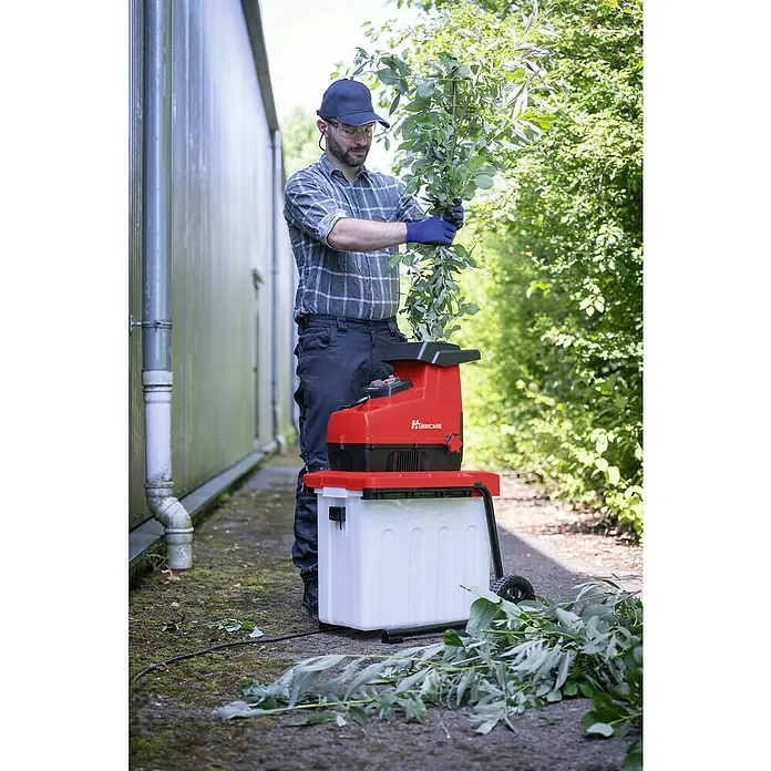 Hurricane Elektro-Leisehäcksler HLH-S-28FB inkl. Zubehör - Max. Aststärke: 4,4 cm, 2.800 W - Ein Mann bedient einen Hurricane Häcksler im Garten, um Äste zu zerkleinern. Effiziente Gartenarbeit mit leistungsstarker Technologie.