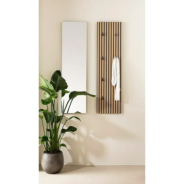 Schildmeyer Ryker Garderobenpaneel - L x B x H: 2,6 x 30 x 110,6 cm, Braun - Eine moderne Garderobenpaneele aus Holz mit schwarzen Akzenten hängt neben einem Spiegel. Ein Zimmerpflanze ziert den Raum.