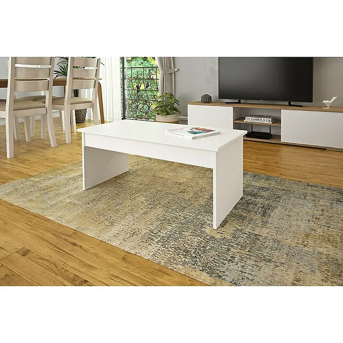 Meka Block Mesa K-503 - L x An x Al: 50 x 100 x 41,6 cm, Blanco soft - Primer plano de una moderna mesa de centro blanca con un libro encima, colocada sobre una alfombra estampada en una sala de estar luminosa.