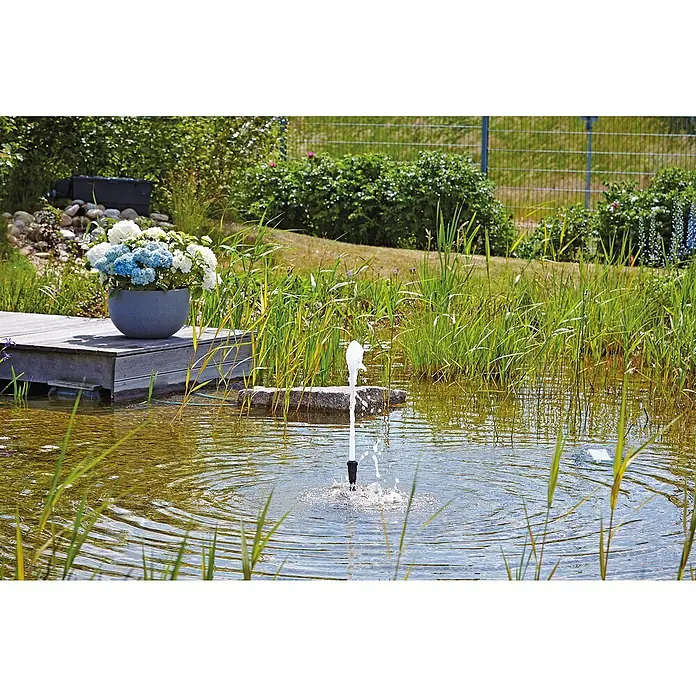 Oase Fontänenaufsatz Schaumsprudler 22 - 5 K - Kunststoff, Max. Förderhöhe: 50 cm - Teichidylle mit einem Springbrunnen in der Mitte und einem Blumentopf am Ufer, der die friedliche Atmosphäre des Gartens unterstreicht.