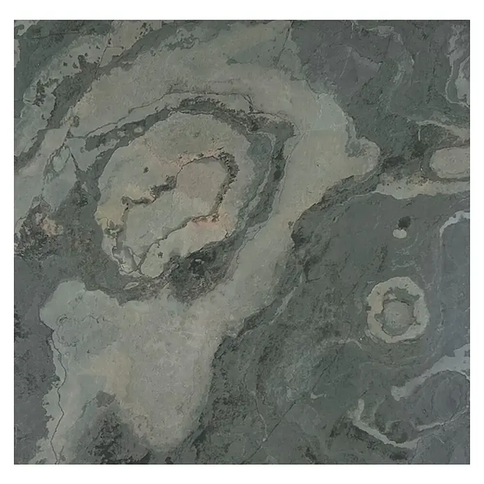 Jangal Wandpaneel Modular Wall Stone - Patina Slate Anel, 520 x 520 x 6 mm - Nahaufnahme einer grünen Steinplatte mit gewundenen Mustern, die eine einzigartige Textur und Farbvariation auf der Oberfläche zeigt.