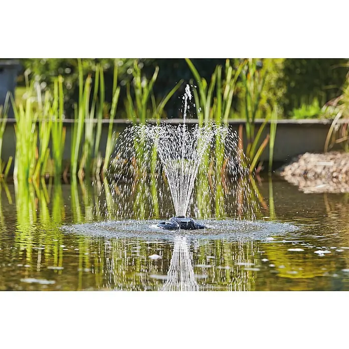 Oase Eisfreihalter IceFree 4 Seasons - Geeignet für: Gartenteiche - Ein Wasserspiel mit einer Fontäne in einem Teich, umgeben von grünen Pflanzen, sorgt für eine entspannende Atmosphäre im Garten.