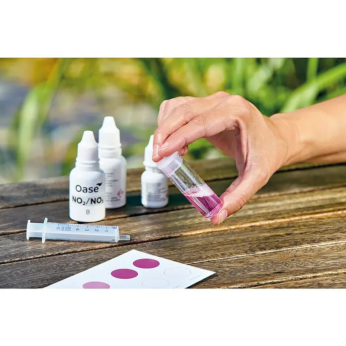 Oase AquaActiv Wasseranalyse-Set - Geeignet für: Gartenteiche - Eine Hand hält einen Behälter mit einer rosa Flüssigkeit, Teil eines Oase NO2/NO3-Testsatzes zur Wasseranalyse.