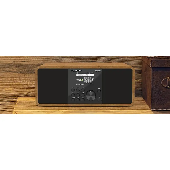 Telestar Internetradio Top 250 - L x B x H: 13 x 27,6 x 11,8 cm, Braun - Ein TeleStar Top 250 Digitalradio im Holzdesign. Das Gerät steht auf einem hölzernen Untergrund und hat ein Display mit Bedienknöpfen.