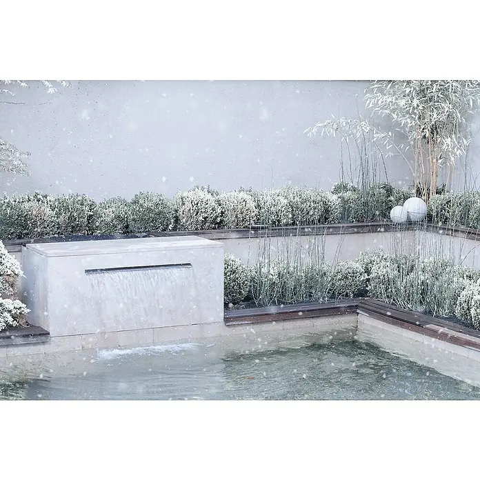 Oase LED-Beleuchtung Illumination 90 - Passend für: Oase Waterfall 90 - Winterliche Gartenszene mit schneebedeckten Büschen, Gräsern und einem modernen Wasserfall, der in einen kleinen Teich mündet. Stimmungsvolles Bild.