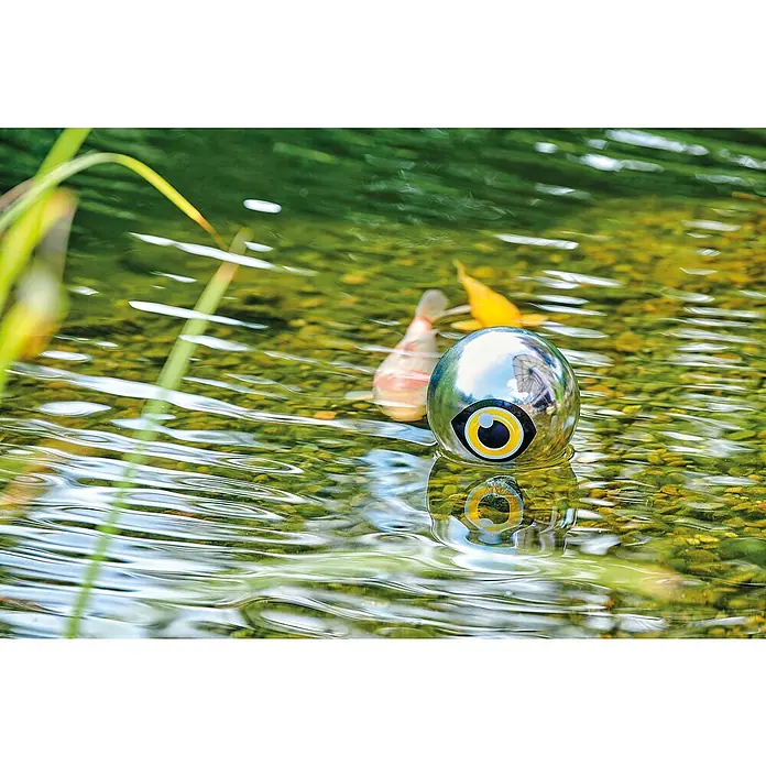 Pontec Reiherschreck PondoScare Ball - L x B x H: 150 x 150 x 168 mm, Geeignet für: Gartenteiche - Glänzender silberner Gartenornament-Ball mit einem stilisierten gelben und schwarzen Auge, das im Wasser auf einer Gartenteichoberfläche schwimmt.