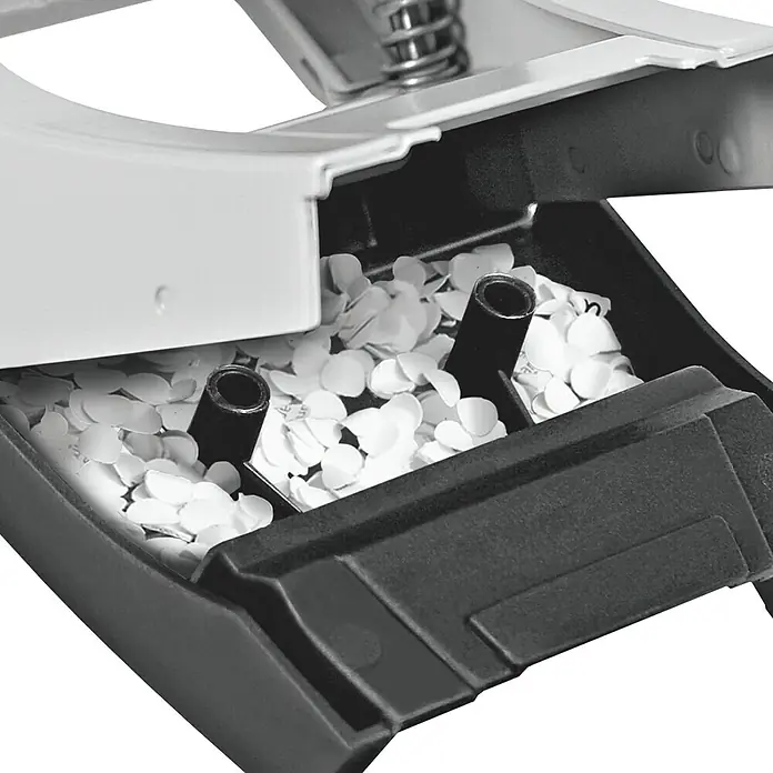 Leitz Locher New NeXXt - L x B x H: 100 x 98 x 84 mm - Detailaufnahme eines Büro-Lochers mit Papierresten, die nach dem Lochen aufgefangen werden. Das Gerät ist aus Kunststoff und Metall.