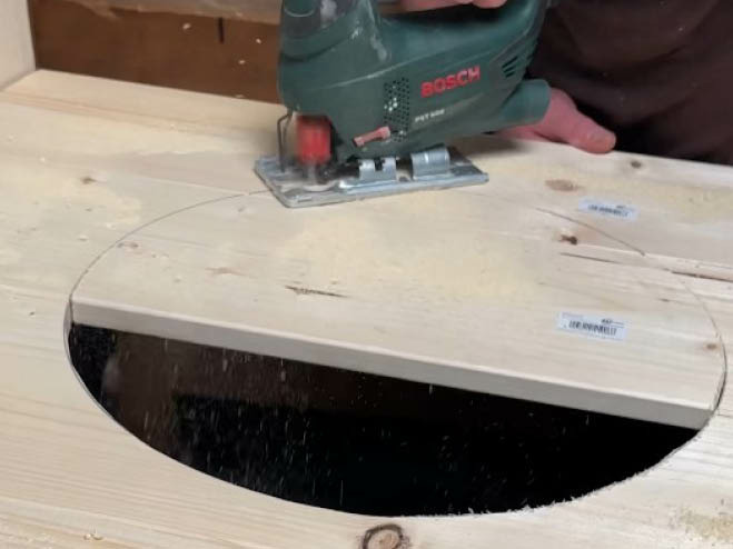 Mit einer Stichsäge wird ein Kreis aus den Glattkantbrettern ausgeschnitten