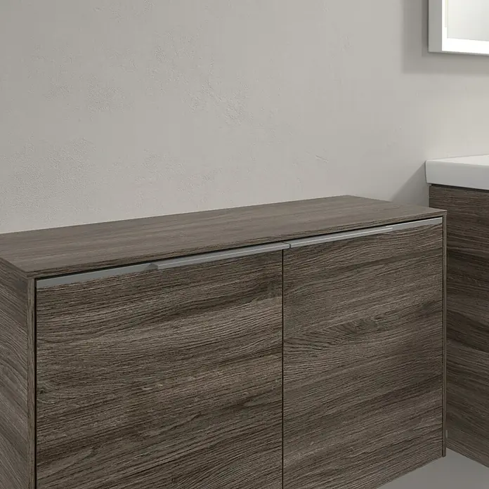 Villeroy & Boch Subway 3.0 Seitenschrank - B x T x H: 72,8 x 25,6 x 42,3 cm, Stone Oak, DIN Anschlag: Links/Rechts, Farbe Griff: Aluminium glänzend - Detailaufnahme eines Badezimmerschranks mit Holzstruktur und silbernen Griffen. Elegantes Möbelstück für das moderne Bad.