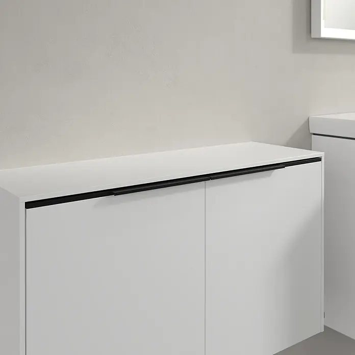 Villeroy & Boch Subway 3.0 Seitenschrank - B x T x H: 72,8 x 25,6 x 42,3 cm, Pure White, DIN Anschlag: Links/Rechts, Farbe Griff: Volcano Black - Nahaufnahme eines modernen, weißen Badezimmerschranks mit schwarzen Griffen, der für stilvolle Aufbewahrung sorgt.