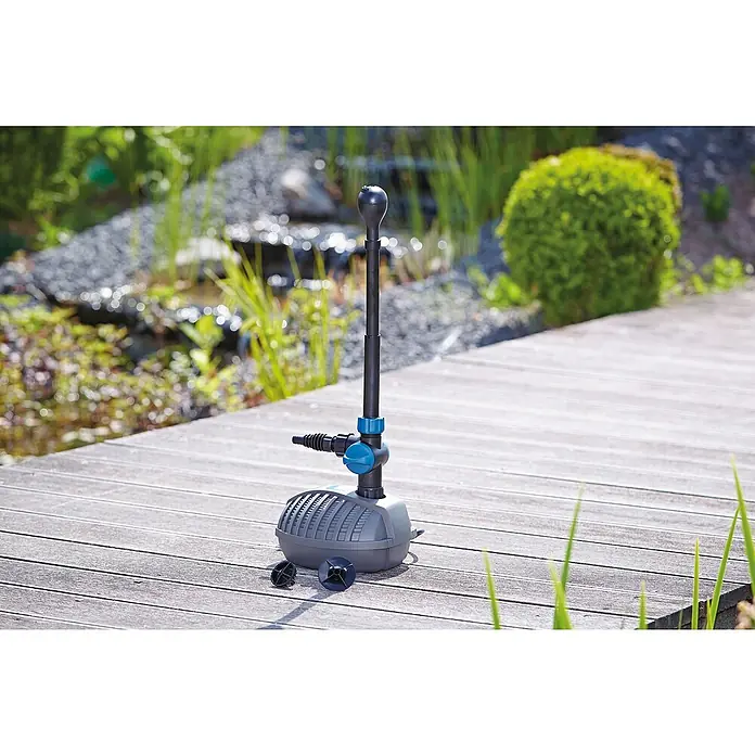 Oase Wasserspielpumpe Aquarius Fountain Set Classic 750 - 9 W, Fördermenge pro Std.: 720 l - Ein Teichpumpe-Set steht auf einem Holzdeck, bereit für den Einsatz im Gartenteich, um Wasser zu zirkulieren und eine Fontäne zu erzeugen.
