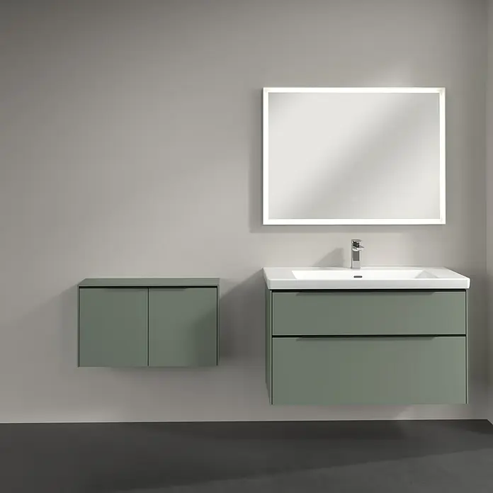 Villeroy & Boch Subway 3.0 Seitenschrank - B x T x H: 72,8 x 25,6 x 42,3 cm, Soft Green, DIN Anschlag: Links/Rechts, Farbe Griff: Volcano Black - Badezimmer-Interieur mit modernem Waschtischunterschrank in Grün, einem passenden Hängeschrank und einem beleuchteten Spiegel.