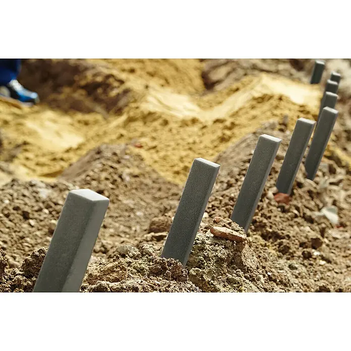 Oase Erdspieß-Set PondEdge - L x B x H: 380 x 40 x 40 mm, 10 Stk., Grau - Nahaufnahme von grauen Betonpfosten, die im Boden befestigt sind und eine moderne architektonische Struktur im Freien bilden.