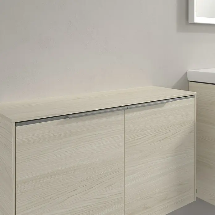 Villeroy & Boch Subway 3.0 Seitenschrank - B x T x H: 72,8 x 25,6 x 42,3 cm, White Oak, DIN Anschlag: Links/Rechts, Farbe Griff: Volcano Black - Nahaufnahme eines Unterschranks mit zwei hellen Holzfronten und Griffleisten, Teil einer Badezimmereinrichtung.