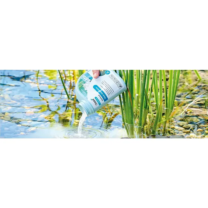 Oase AquaActiv Teichpflegemittel Teich-Stabilisierer Optipond - 500 ml - Eine Flasche Oase Teich-Stabilisierer wird in einen Teich gegossen. Das Produkt stabilisiert das Teichwasser und sorgt für ein gesundes Teichklima.