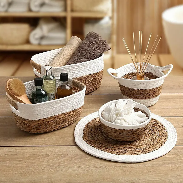 Versa Cesta redonda - Blanco, Con asa - Cestas decorativas de almacenamiento: Un conjunto de cestas de mimbre en tonos naturales y blancos, ideales para accesorios de baño y organización elegante.