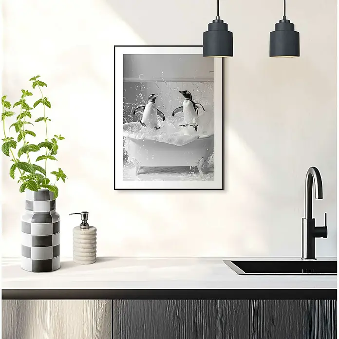 Reinders Bild Slim Frame Black - Penguin Party, B x H: 30 x 40 cm - Ein Schwarz-Weiß-Kunstdruck mit spielenden Pinguinen in einer Badewanne, gerahmt und an einer weißen Wand über einer modernen Küchentheke angebracht.