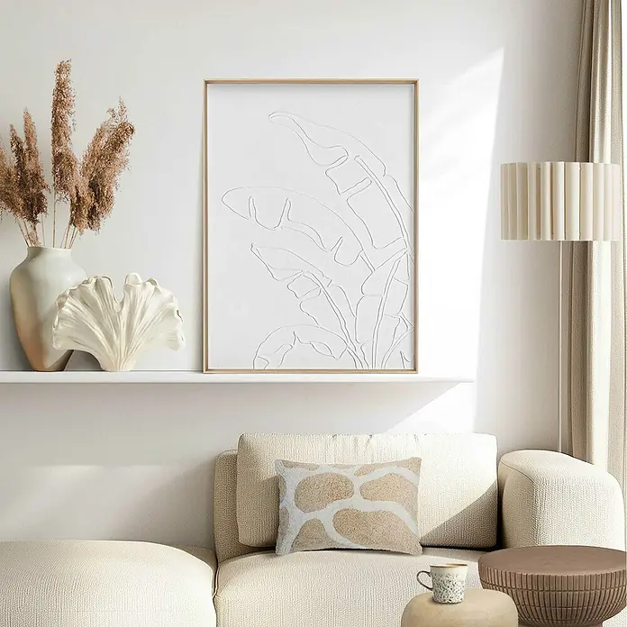 Reinders Bild Craft Art - Palm Leafs, B x H: 50 x 70 cm - Einrichtungsidee mit einem minimalistischen Pflanzenbild an einer weißen Wand über einem beigen Sofa mit gemustertem Kissen.