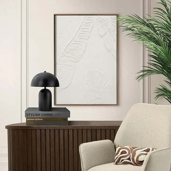 Reinders Bild Craft Art - Tropical Leafs, B x H: 50 x 70 cm - Nahaufnahme eines stilvollen Interieurs mit einem abstrakten weißen Leinwandbild an der Wand und einer schwarzen Lampe auf einer Kommode.