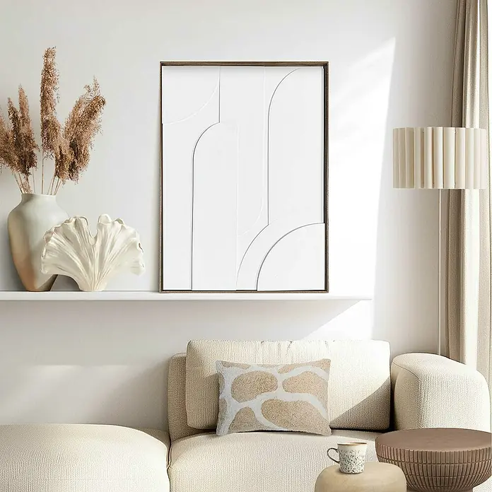 Reinders Bild Relief Art - Layered Geometrics, B x H: 50 x 70 cm - Ein gerahmtes abstraktes weißes Kunstwerk hängt über einem Sofa, neben einer Vase mit Federn und einem korallenen Dekorstück.