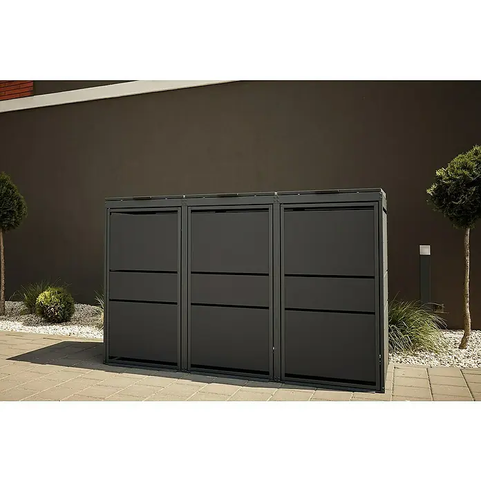 Mülltonnenbox Modern 120L - 236,6 x 70 cm, Stahl, Anthrazit, Geeignet für Anzahl Mülltonnen: 4 Stk. - Drei graue Mülltonnenboxen stehen auf einem gepflasterten Bereich, umgeben von Kies und Grünpflanzen. Die Boxen bieten eine elegante Mülltonnenverkleidung.