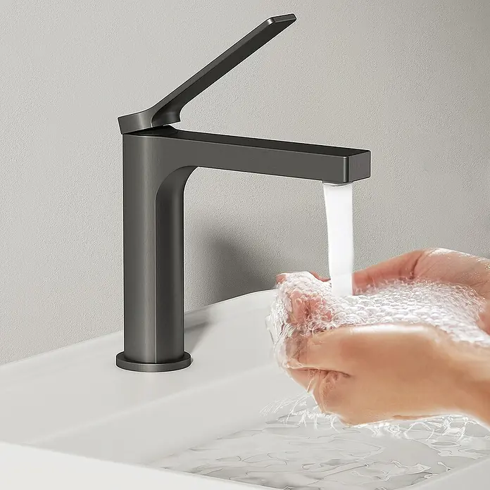 Emke Waschtischarmatur Zerona F21 - Grau, Matt - Eine moderne, anthrazitfarbene Waschtischarmatur wird in einem Badezimmer mit strahlendem Wasserfluss über einem Waschbecken gezeigt.