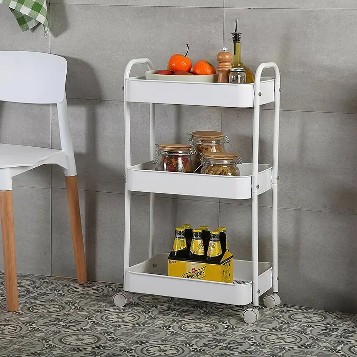 Versa Carro con ruedas - 30 x 46 x 76 cm, Acero, Blanco - La imagen muestra un carrito de cocina blanco con tres estantes, cargado con alimentos y bebidas, contra una pared gris.