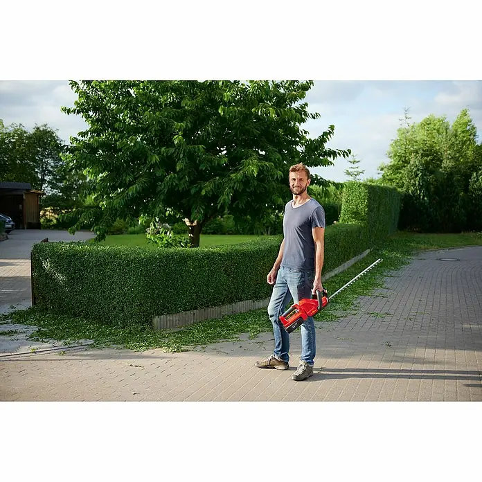 Wolf-Garten Akku-Heckenschere Lycos 40/500 H - 40 V, Li-Ionen, 1 Akku, Schnittlänge: 50 cm - Ein Mann hält eine rote Heckenschere der Marke WOLF-Garten, ideal zum Trimmen von Hecken und Sträuchern im Garten.