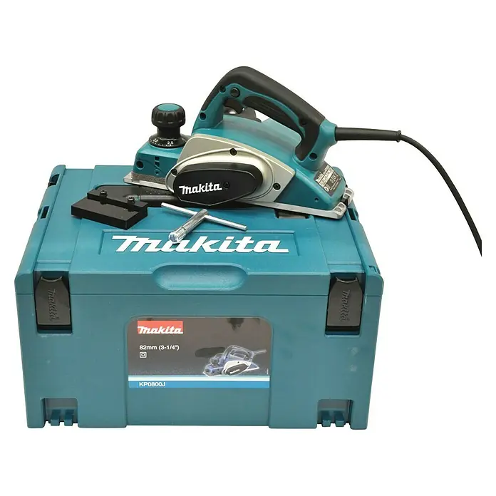 Makita Handhobel im MAKPAC KP0800J - 620 W, Hobelbreite: 82 mm, Falztiefe: 9 mm - Makita Elektrohobel KP0800J auf einem Werkzeugkoffer. Das Set beinhaltet Zubehör für den Hobel.