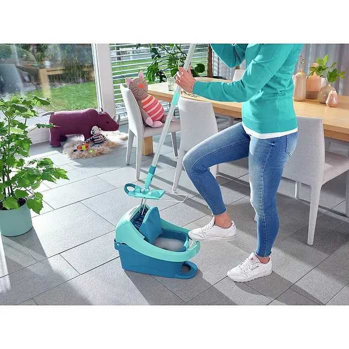 Leifheit Bodenwisch-Set Profi XL Mobile - 3 -tlg. - Eine Frau benutzt einen türkisfarbenen Bodenwischer mit Eimer auf einem gefliesten Boden. Das Reinigungsgerät ist das Hauptaugenmerk des Bildes.