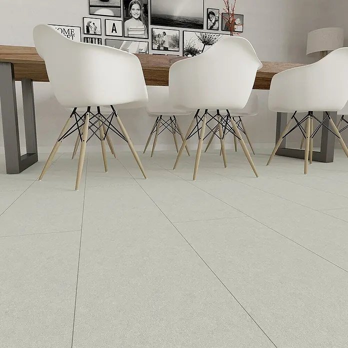 Hyundai L & C PVC-Bodenbelag Fix Verlegt - Selbstklebend, 31 cm x 10,7 m, Dolomit - Weiße Armlehnstühle mit hellen Holzbeinen stehen um einen Holztisch auf einem grauen Fliesenboden und schaffen eine moderne Essbereich-Atmosphäre.