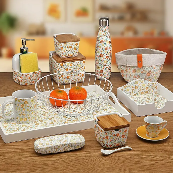 Versa Juego de cestas - Flores naranja, 3 ud. - Una colección de utensilios de cocina con estampado floral, incluyendo recipientes, tazas y una cesta de fruta, mostrados sobre una mesa de madera.