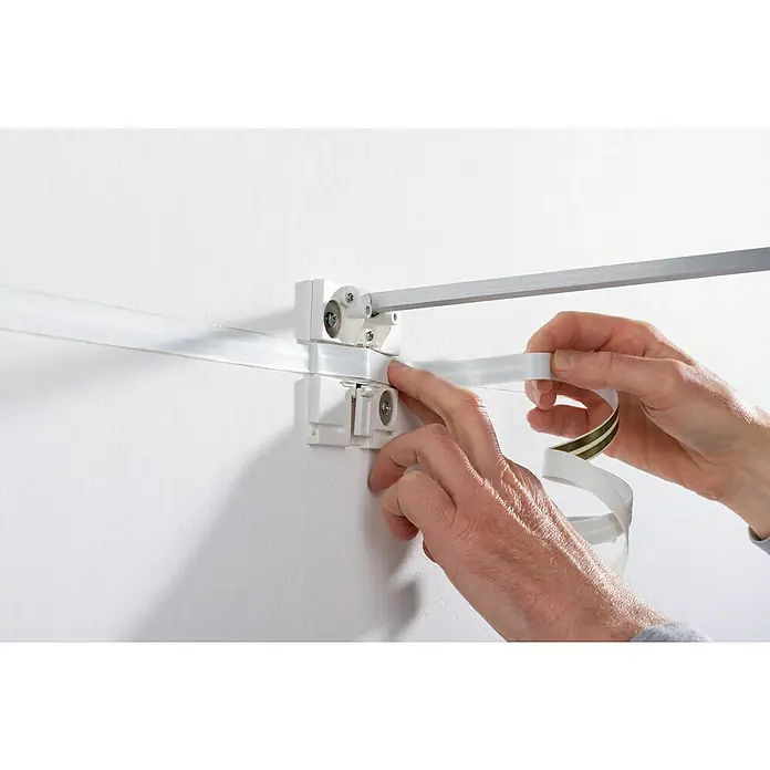 Paulmann Flachkabel - Länge: 400 cm, Geeignet für die Paulmann LED-Bilderleuchten Xana und Adelia, Weiß - Jemand befestigt ein flexibles Schienensystem an einer Wand mit doppelseitigem Klebeband, um flexible Beleuchtungslösungen zu schaffen.